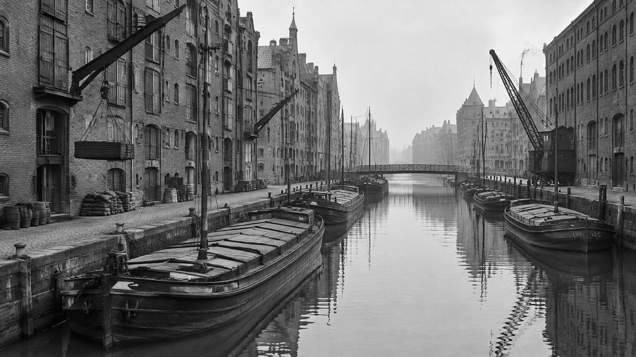 Historic harbour warehouse district with barges on the water in black and white